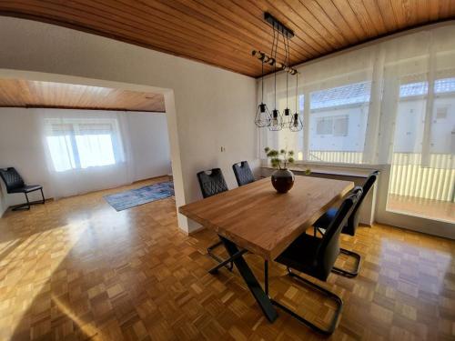 a dining room with a wooden table and chairs at Zentrale, Helle Ferienwohnung in Crailsheim
