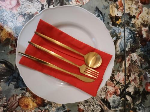 a plate with a fork and a red napkin at Rose & Star Cottage in Frome