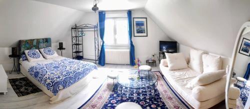 ein Wohnzimmer mit einem Sofa und einem Tisch in der Unterkunft Maison d'hôte privatisée avec piscine et jacuzzis 15 pers max in La Couture-Boussey