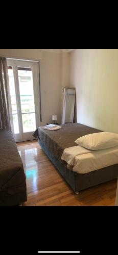 ein Schlafzimmer mit einem Bett und einem großen Fenster in der Unterkunft athens oasis in Athen