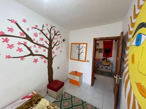 a bedroom with a tree mural on the wall at Vlora Backpackers Hostel & Bar LUNGOMARE in Vlorë