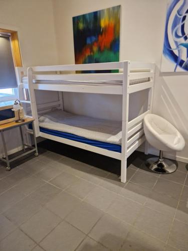 a white bunk bed with a desk and a chair at Lilla Stuga in Moheda