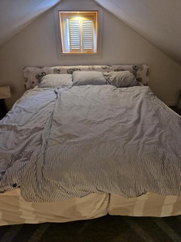 a large bed in a bedroom with a window at Lilla Stuga in Moheda