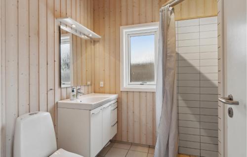 a bathroom with a toilet and a sink and a window at Nice Home In Sby With 3 Bedrooms And Wifi in Sæby