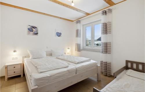 1 dormitorio con 2 camas y ventana en Ferienhaus 2 Altefhr, en Altefähr