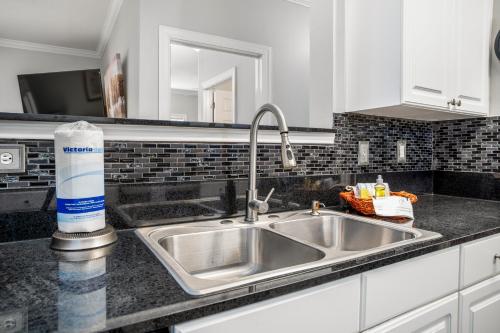 um lavatório de cozinha com uma garrafa de agente de limpeza em Park Avenue 109 em Foley