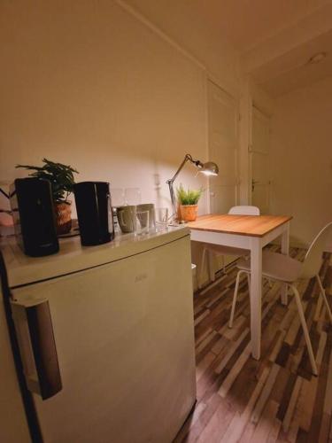 a kitchen with a table and a desk with a lamp at Cozy Private Room 2 on a Busy Persian Restaurant in Eindhoven