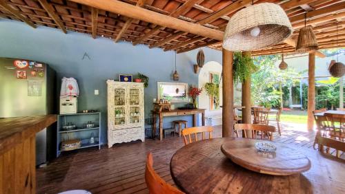 cocina y comedor con mesa de madera y sillas en Vila Pitanga Trancoso, en Trancoso