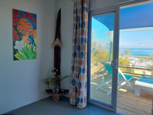 a room with a sliding glass door with a view of the ocean at Blue View Terrace in Rodrigues Island