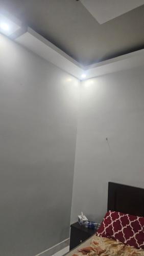 um quarto com uma cama e uma parede branca em Hotel Karachi em Karachi