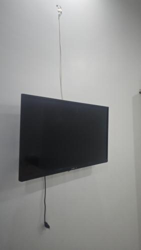 TV de pantalla plana colgada en la pared en Hotel Karachi, en Karachi