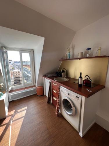 une cuisine avec une machine à laver et un évier dans l'établissement Sublime Appartement Parisien, à Paris