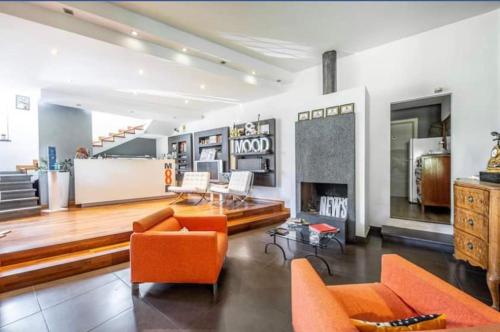 sala de estar con muebles de color naranja y chimenea en Ottomood B&B and Apartments, en Tremestieri Etneo