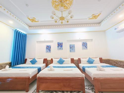 Habitación con 4 camas y lámpara de araña. en Phuong Thuy Hotel, en Can Tho