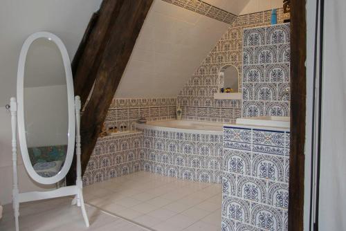 ein Bad mit einer Badewanne und einem Spiegel in der Unterkunft Maison d'hôte privatisée avec piscine et jacuzzis 15 pers max in La Couture-Boussey