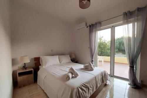 a bedroom with a white bed with towels on it at Apartment in Karellas near the airport in Paianía