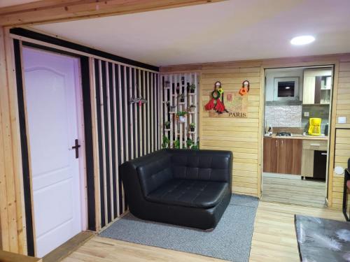 a black leather chair in a room with a kitchen at Cabana Rosie in Vartop