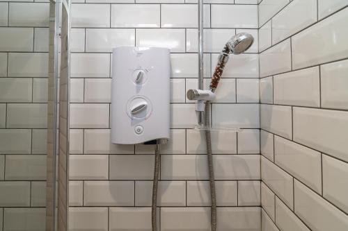 eine Dusche in einem Badezimmer mit weiß gefliesten Wänden in der Unterkunft Light airy 3 bed Town Cntr flat 700m to the Beach in Bournemouth