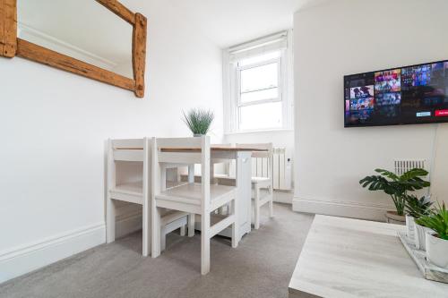 a white dining room with a table and a window at Spacious 3-Bed, Town Centre, Parking, Near Beach in Bournemouth