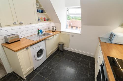 a kitchen with a sink and a washing machine at Spacious 3-Bed, Town Centre, Parking, Near Beach in Bournemouth