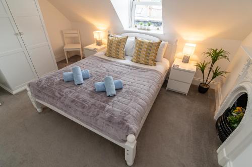 sypialnia z łóżkiem z 2 niebieskimi poduszkami w obiekcie Light airy 3 bed Town Cntr flat 700m to the Beach w Bournemouth