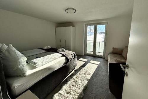 1 dormitorio con cama, sofá y ventana en My Appartements en Untertauern