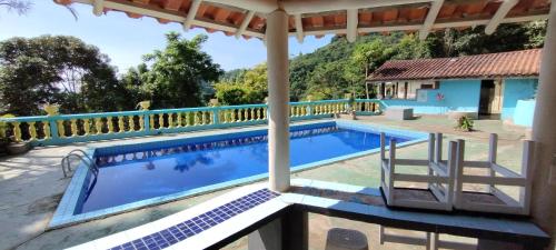 uma vista para uma piscina numa casa em Chalé Mirante do Félix (Amarelo) em Ubatuba