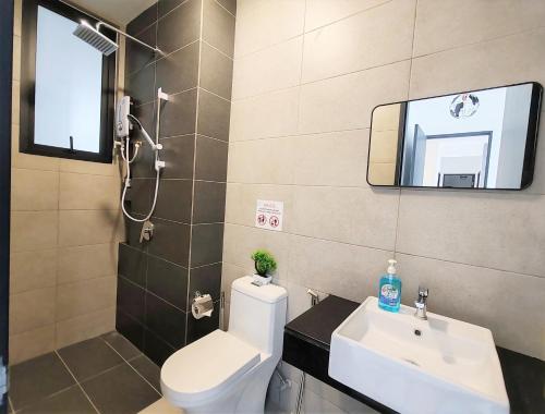 a bathroom with a toilet and a sink and a mirror at Cozy Minimalist Suite at Georgetown by SuperStay in Jelutong