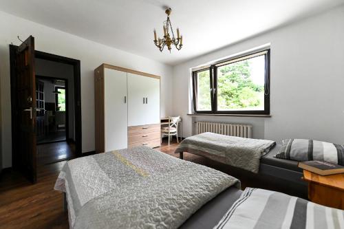 1 Schlafzimmer mit 2 Betten und einem Fenster in der Unterkunft Dom Gościnny Rzeczna 4 in Tuczno