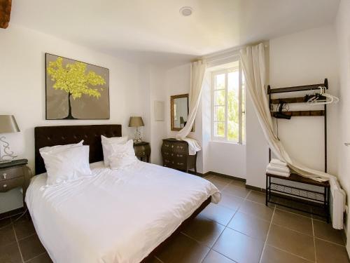 a bedroom with a white bed and a window at L'Enea Terrasse in Saint-Cyprien