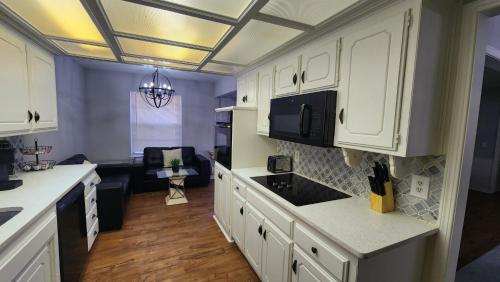 een keuken met witte kasten en een zwarte wastafel bij Family Home in Oklahoma City
