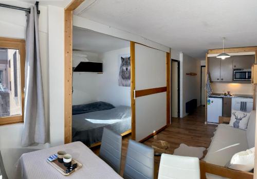 Il comprend un petit salon avec une table et une cuisine. dans l'établissement Le V - 2 bedrooms flat in the middle of Val Thorens, à Val Thorens
