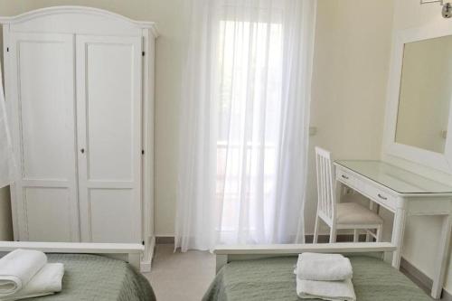 a bedroom with a bed and a desk and a mirror at Villa Hara, Lixouri, Kefalonia in Lixouri