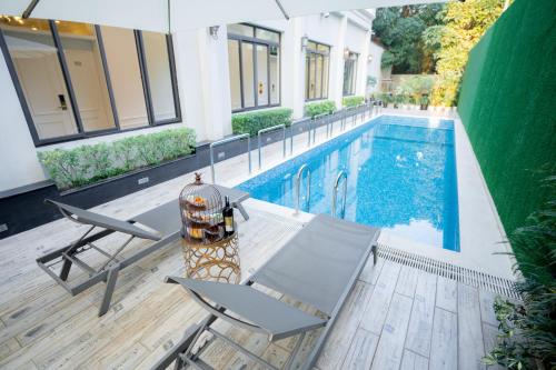 a swimming pool with a table and chairs next to a house at Le Haute Hotel Hai Phong in Hai Phong