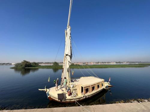 a boat tied up to a dock in the water at Nile Felucca Adventure in Aswan