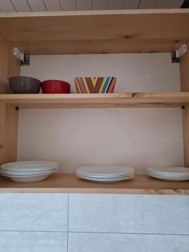 a shelf with plates and bowls in a kitchen at Apartmani "DA HOX" Vlašić 1 in Vlasic