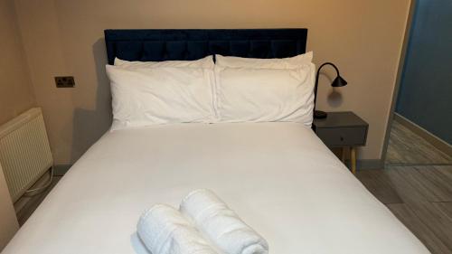 a bed with white sheets and pillows on it at One Bedroom Apartment in Walsall Sleeps 4 FREE WIFI By Villazu in Bloxwich