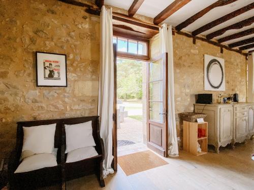 サン・シプリアンにあるMoon River Grande Maisonのベッド1台と開放ドアが備わる客室です。