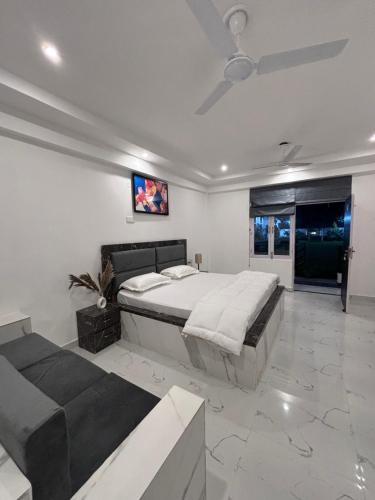 - une chambre avec un grand lit et un canapé dans l'établissement Inara Farms, à Lucknow