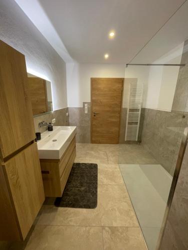 a bathroom with a white sink and a shower at Ferienwohnung Moser in Hauzenberg