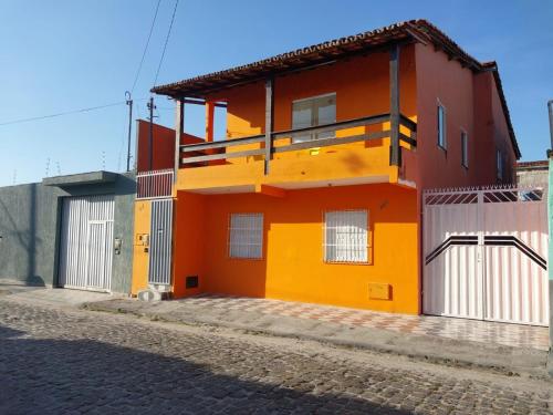 a orange and yellow house on a street at casa grande e tranquila in Porto Seguro