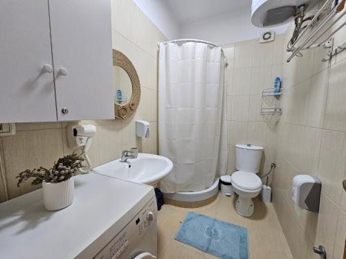 ティラナにあるVibe Studio Apartmentの白いバスルーム(トイレ、シンク付)