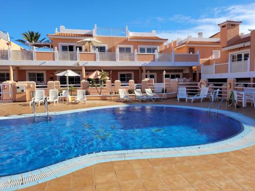 a large swimming pool in front of a resort at Apartamento funcional en residencial con piscina en inmejorable ubicación en centro de la isla in Caleta De Fuste