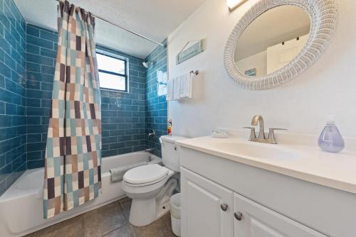 ein Badezimmer mit einem Waschbecken, einem WC und einem Spiegel in der Unterkunft Beach Villa 2 Bedroom in Clearwater Beach