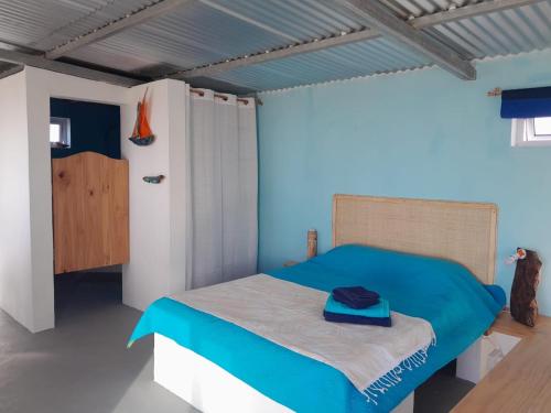 a bedroom with a bed with a blue comforter at Blue View Terrace in Rodrigues Island