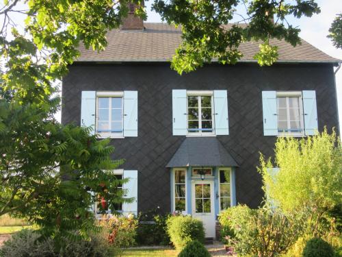 a black house with white shutters at Le Clos Lauradière in Cormeilles