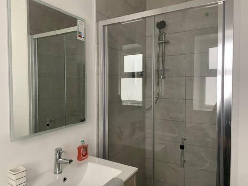 a bathroom with a shower and a sink and a mirror at Modern appartment with sea views in Portrush