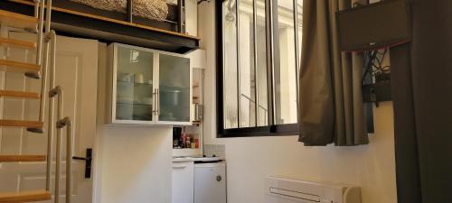 uma cozinha com um frigorífico branco e uma janela em Studio Marais Ménilmontant em Paris