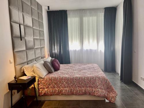 sypialnia z dużym łóżkiem i oknem w obiekcie Estudio junto La Nogalera 1 w mieście Torremolinos