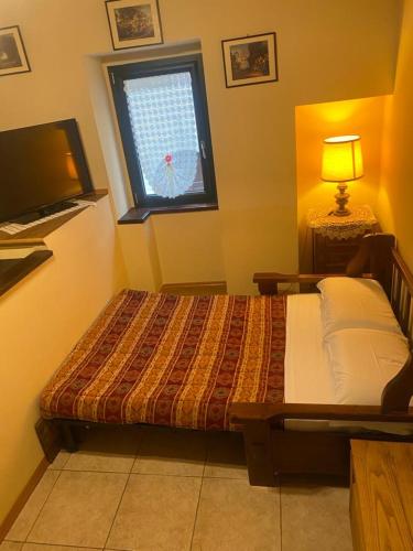 a bedroom with a bed and a window at La casetta della nonna in Caramanico Terme